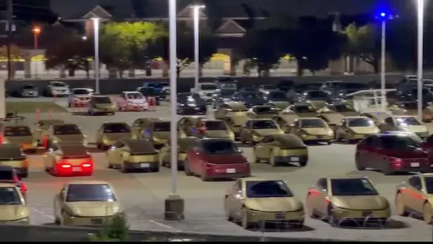 A row of gold-colored Tesla Cybercabs staged in an Austin parking lot ahead of public deployment