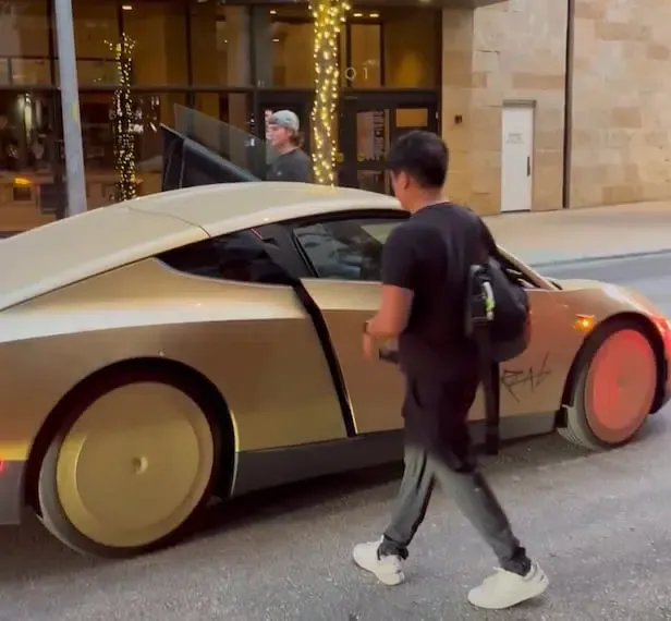 Passersby filming the driverless Tesla Cybercab operating along public roadways in Austin