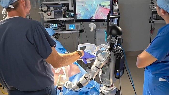 A general-purpose Unitree G1 robot standing at the operating table
